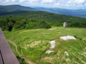 The view north on the A.T. from the observation tower on Bromley Mountain; a large rectangular concrete block with white blazes painted on it is in view