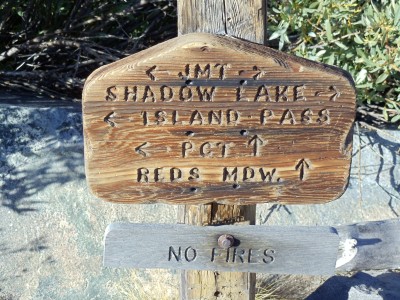 Trail sign at Thousand Island Lake for the PCT/JMT split: the PCT heads straight toward the ridge, while the JMT continues to the right around half a dozen lakes
